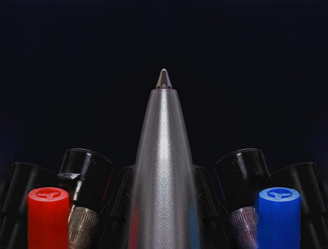 A group of different colored pens sitting next to each other