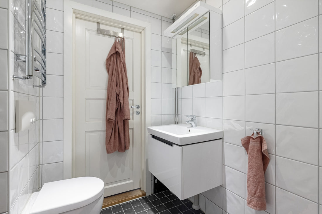 A bathroom with a toilet, sink and mirror