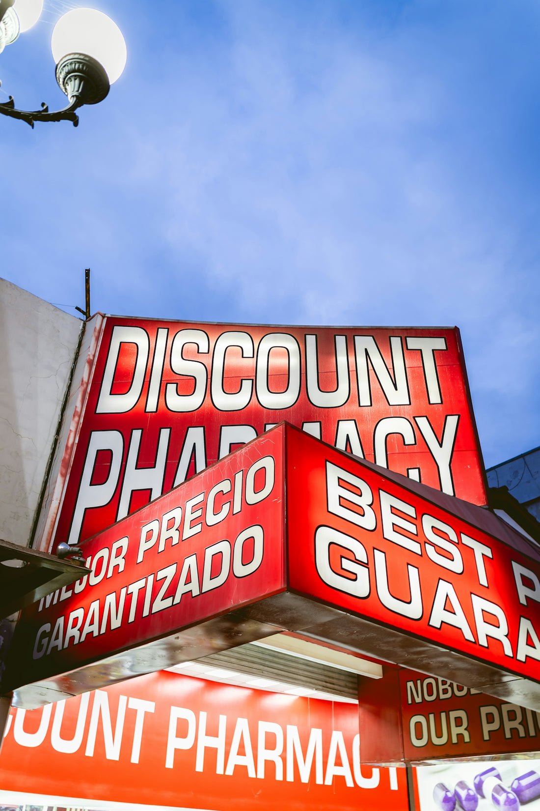 Discount pharmacy sign illuminated at dusk.